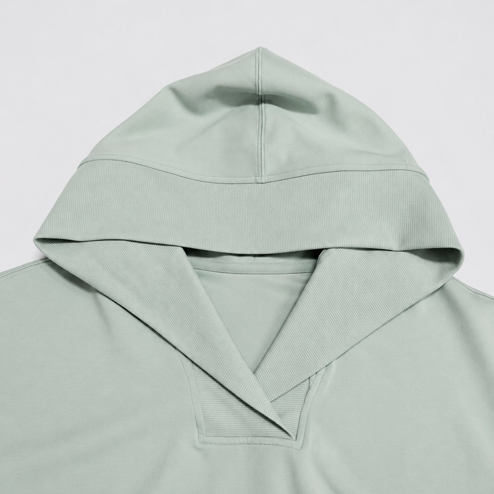 Overlapping rib trim at the V-neck and hood of the sage-green lounge top