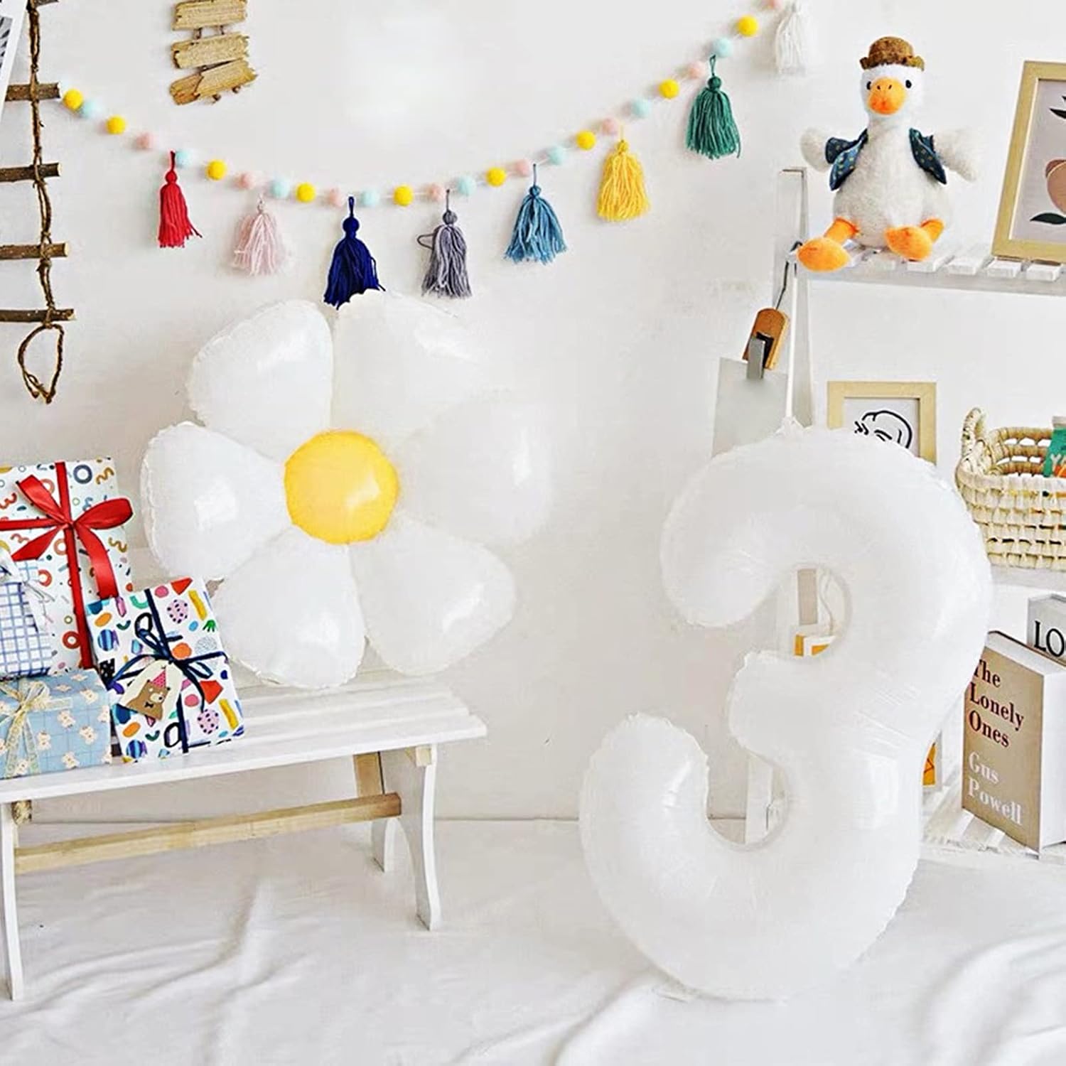 White daisy flower decorations with yellow centers in a birthday room display