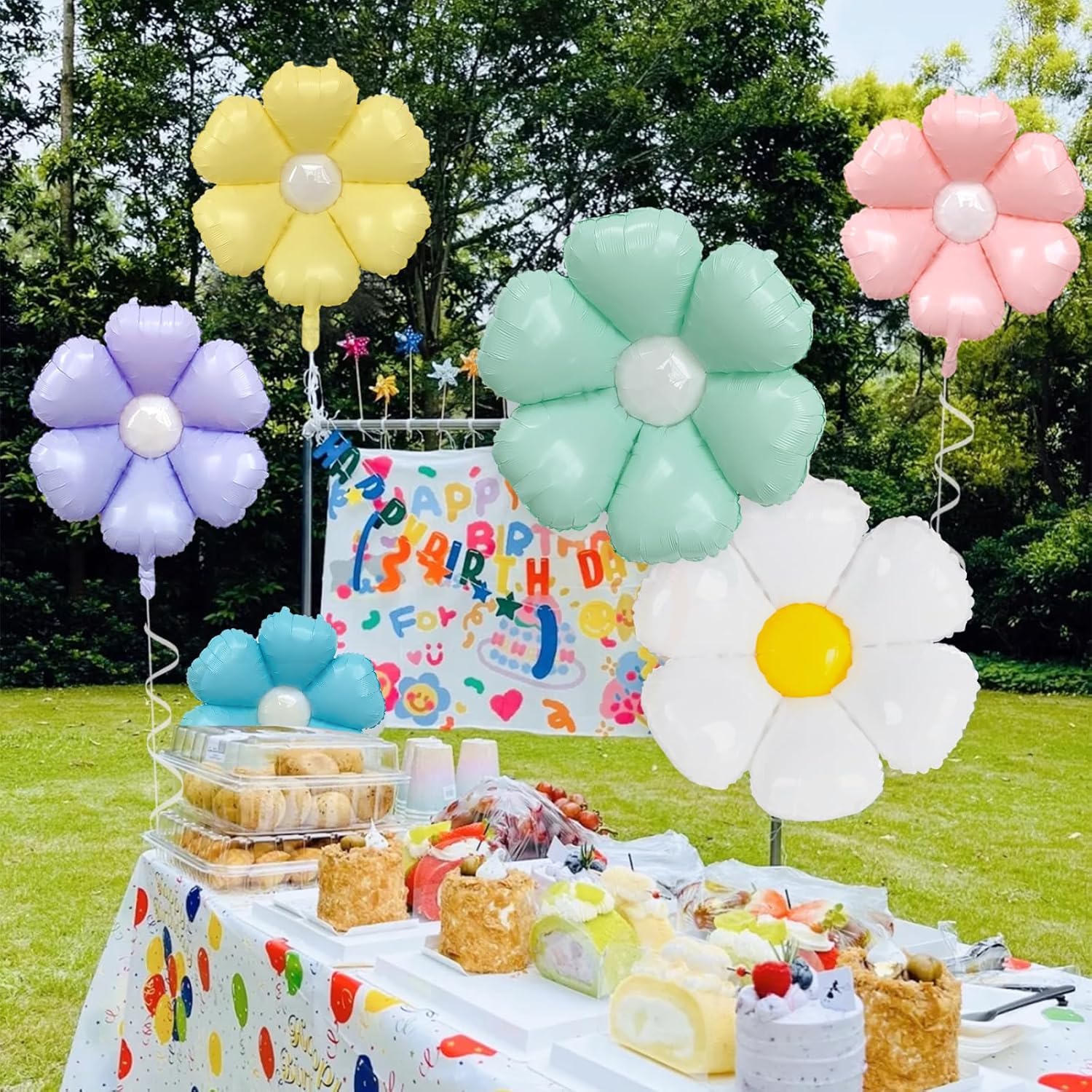 Pastel flower and white daisy decorations around an outdoor party table