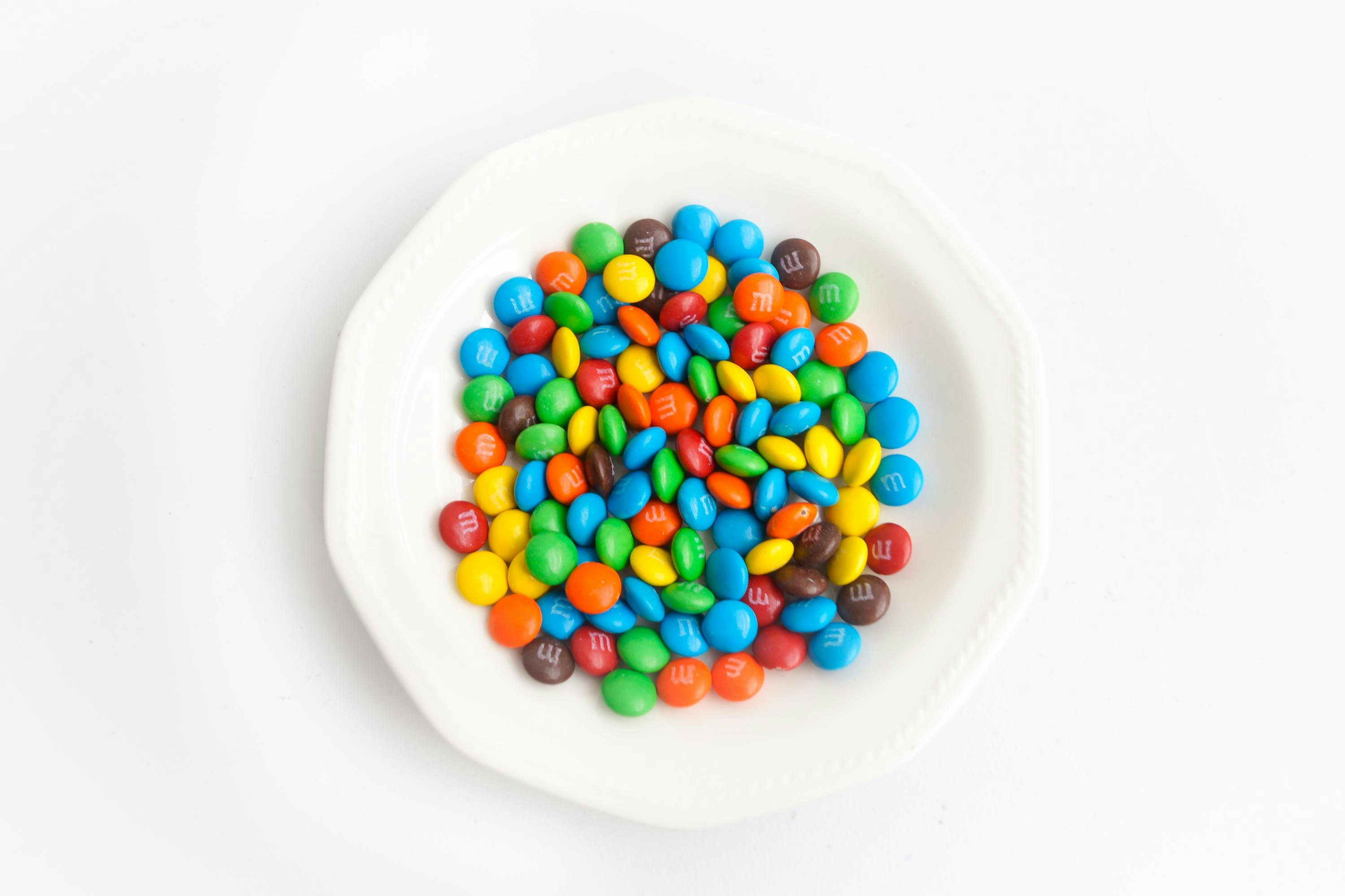A variety of chocolate beans in a bowl, highlighting their different shapes and colors.