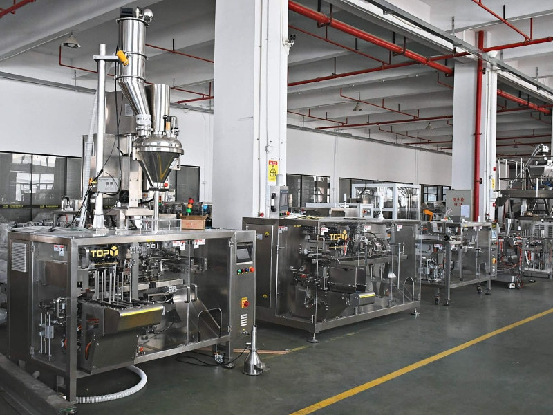 Food packaging machines with transparent safety guards on the assembly floor