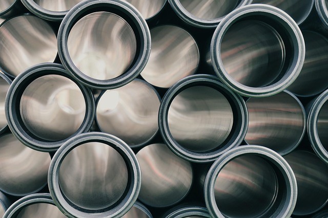 Metal pipe ends stacked on an industrial site where aluminum jacketing is used