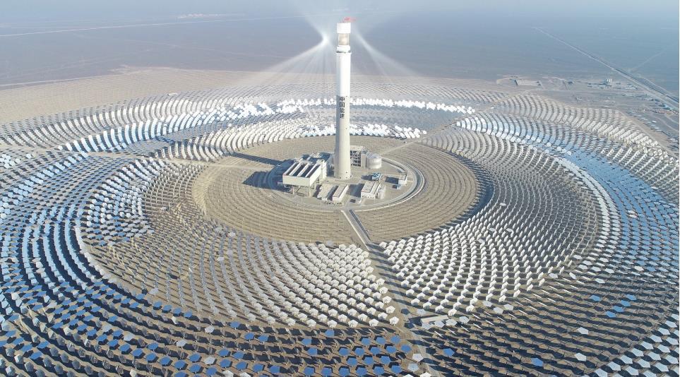 Rows of reflective laminates facing the sun across a concentrated solar power field in a desert location