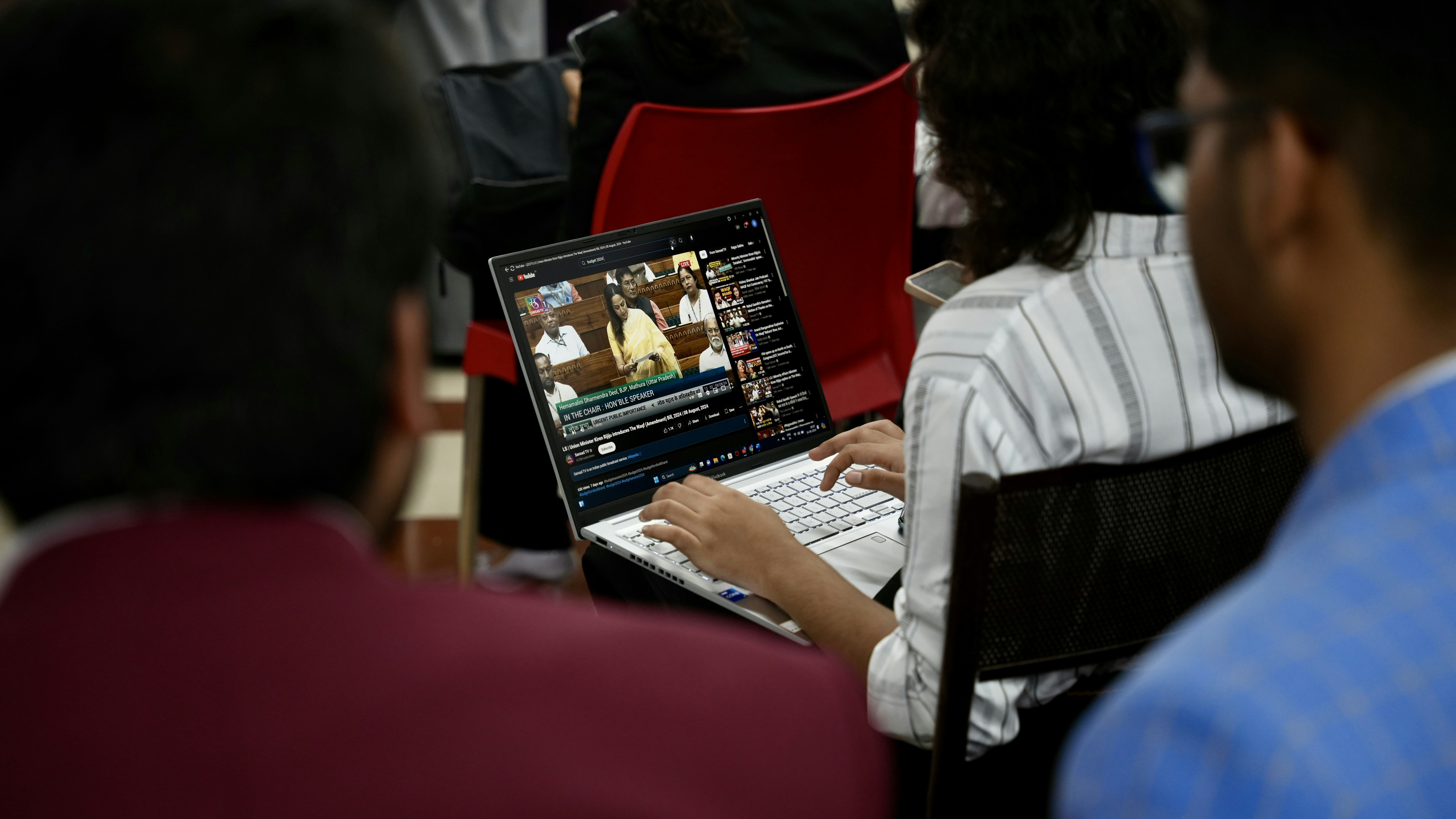 A person at a conference using a laptop to manage the event