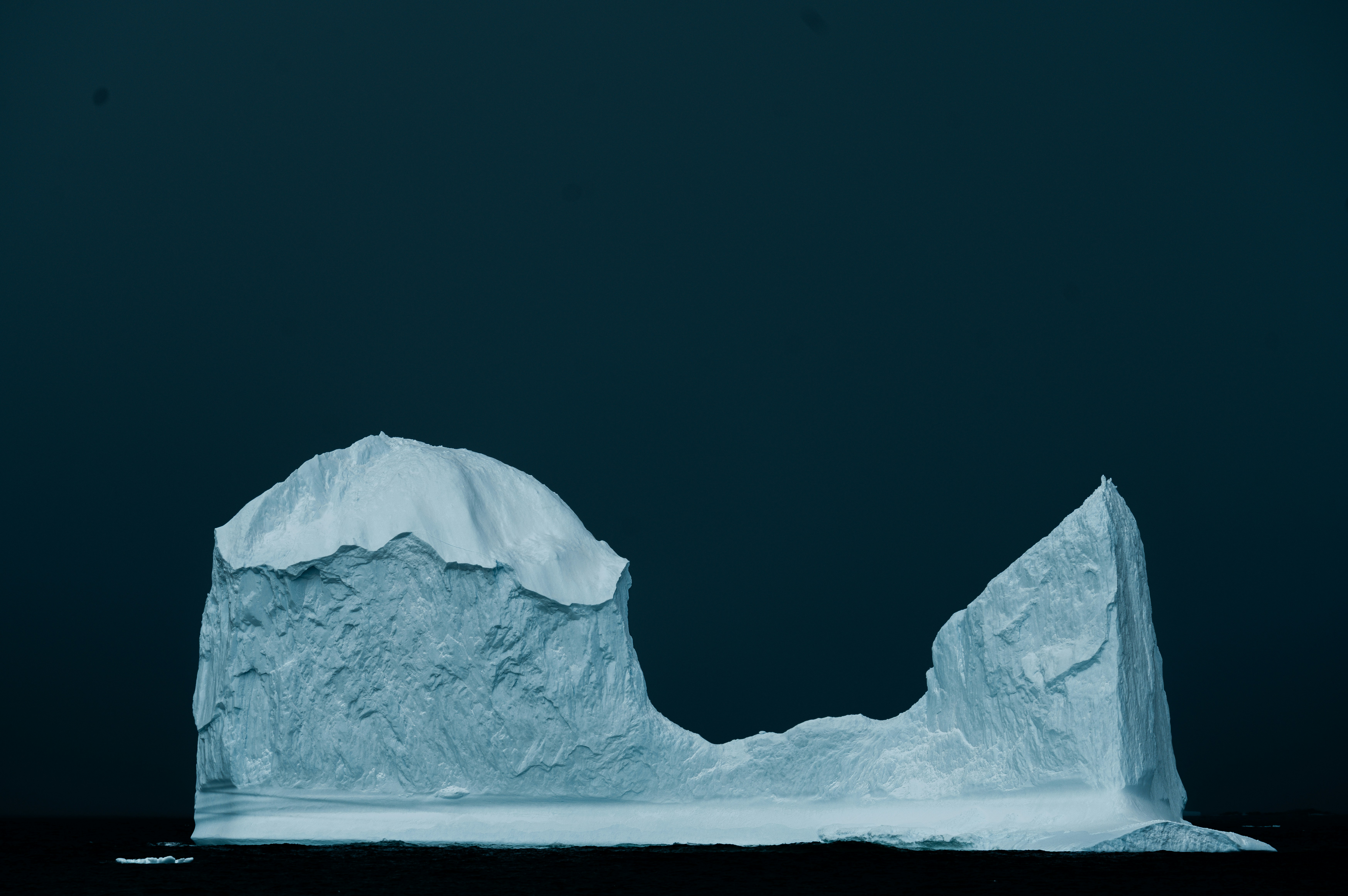 An iceberg diagram showing the visible purchase price above the water and the much larger hidden costs of maintenance and downtime below.