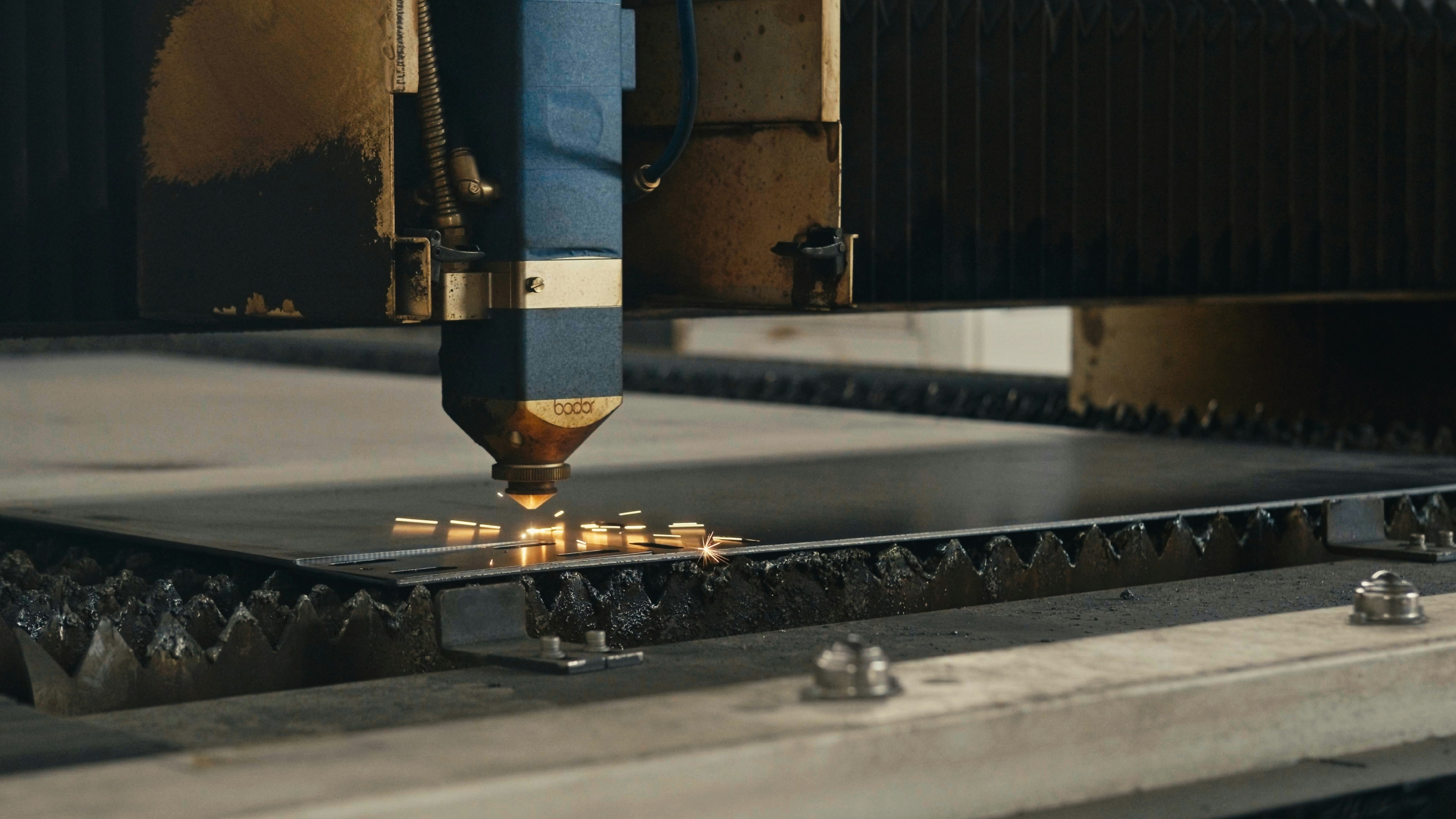 A CNC laser cutter precisely cutting a complex pattern out of a sheet of steel