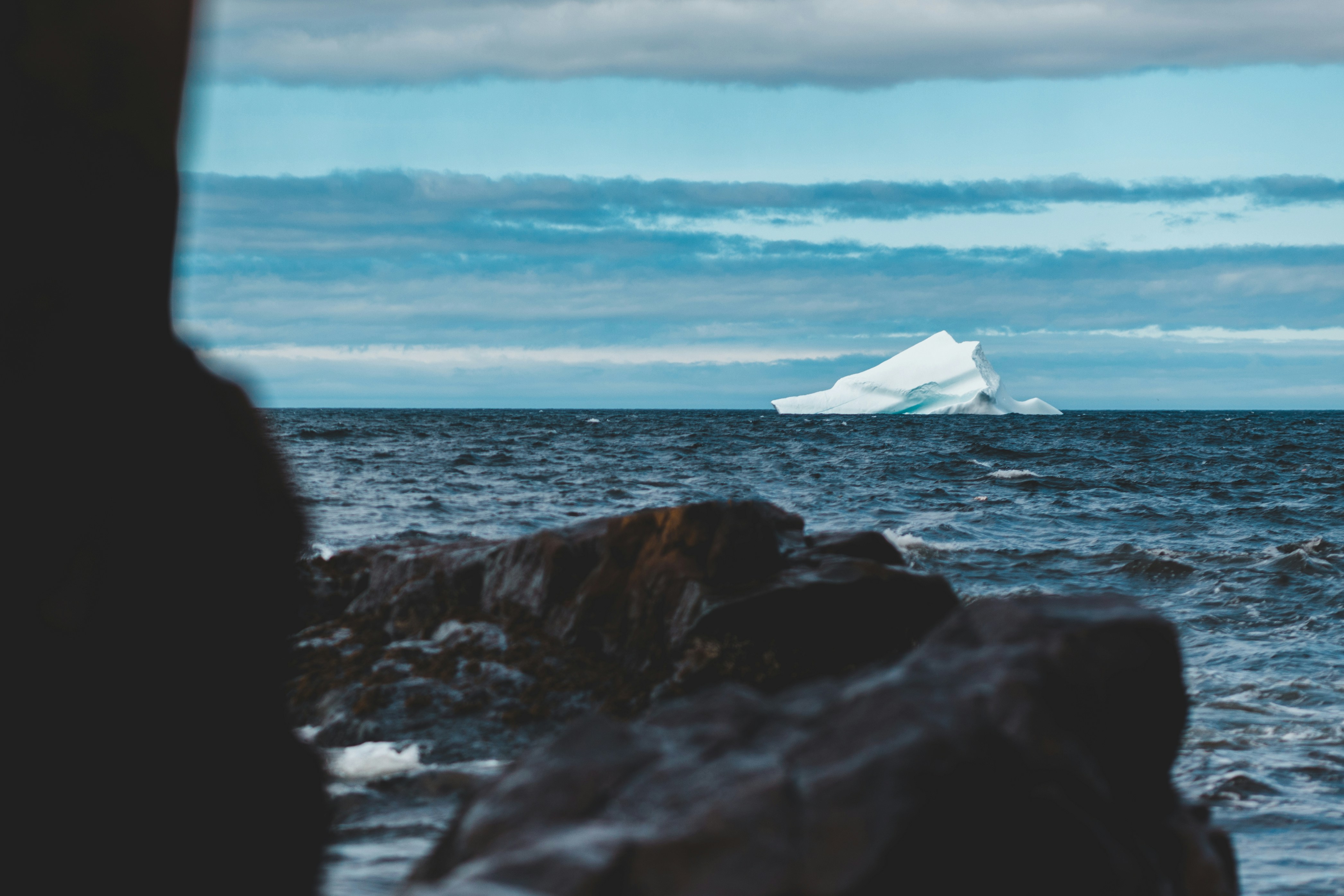 An infographic showing an iceberg where the tip is the initial price and the submerged part lists hidden costs like rework, downtime, and reputational damage.