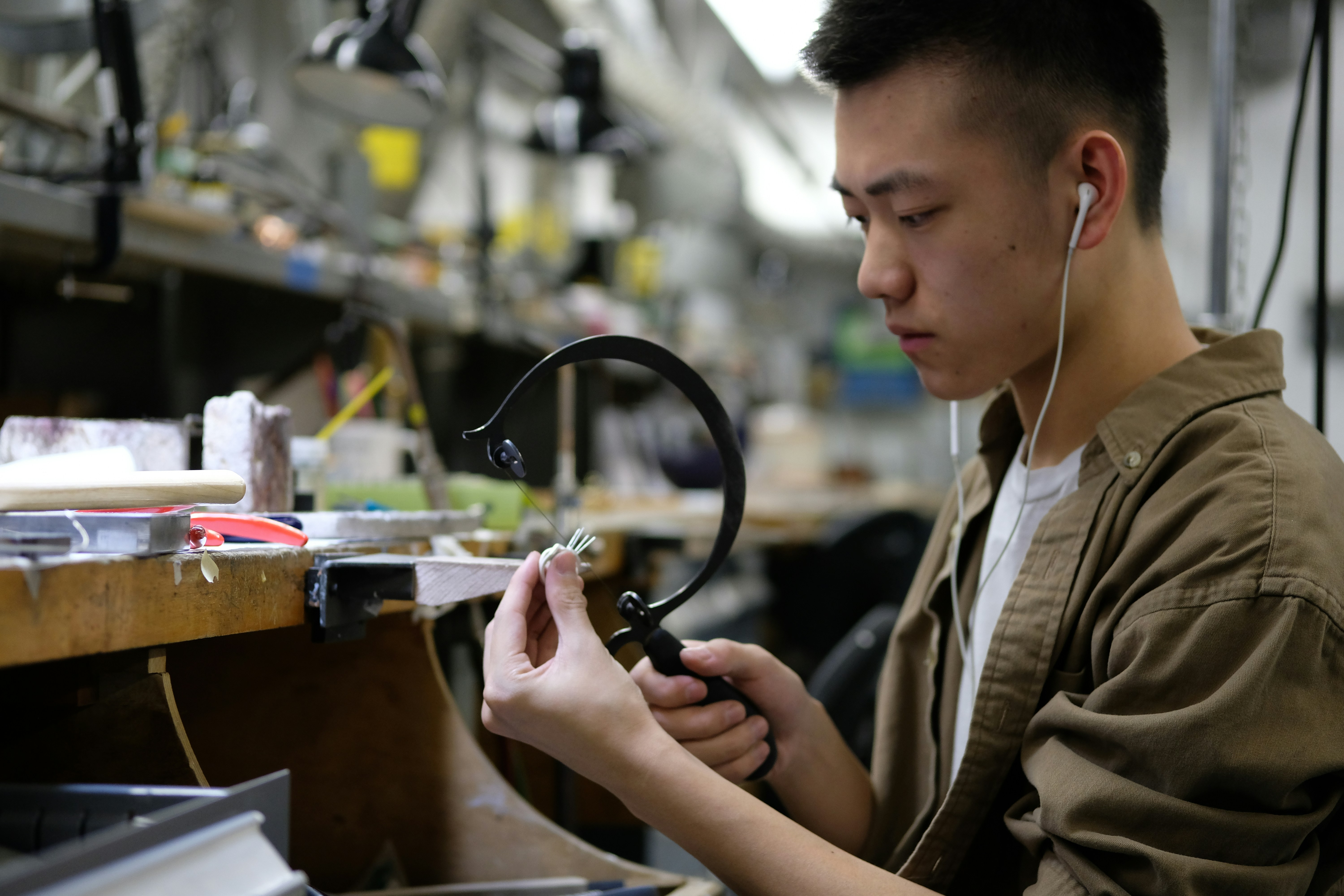 An inspector using digital calipers to measure a finished sheet metal part on a workbench