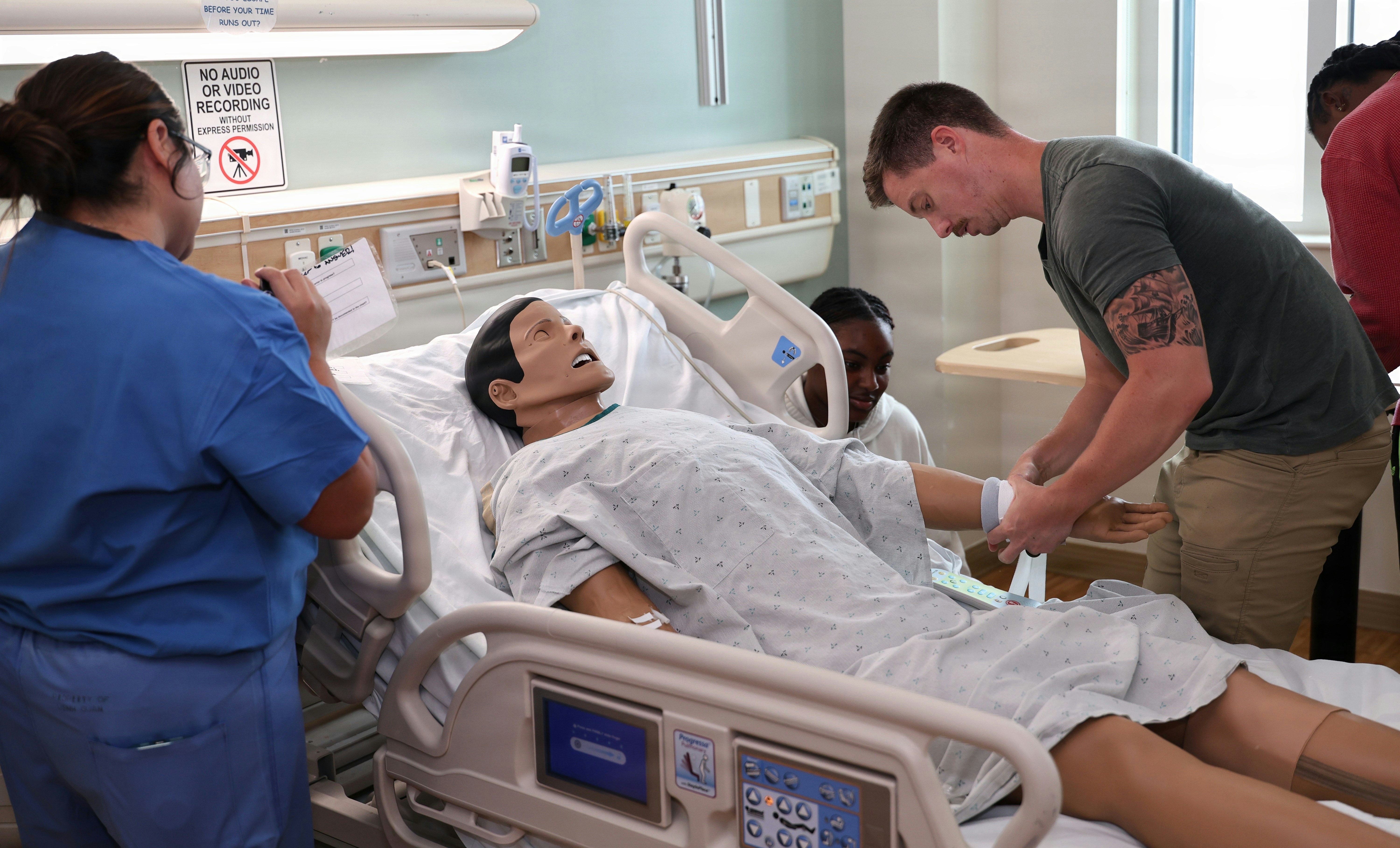 Clinicians Focusing on Patient Care A clinical team focused on a patient in an emergency room, with the operator console working in the background.