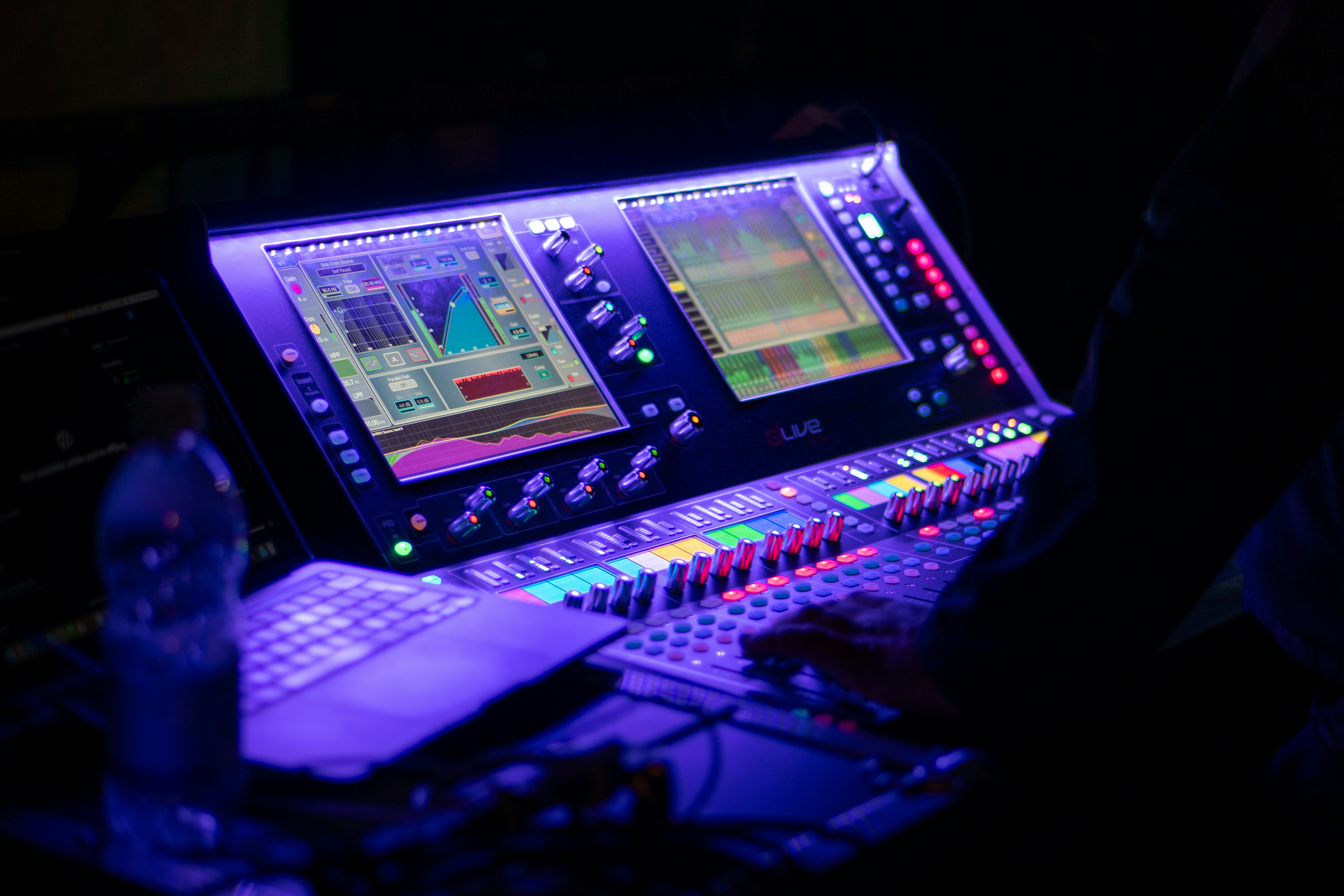 A lighting designer using a multi-touch screen on a control console to select colors.