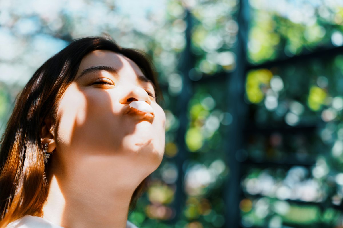 Person practicing meditation pose outdoors, representing calm and focused awareness