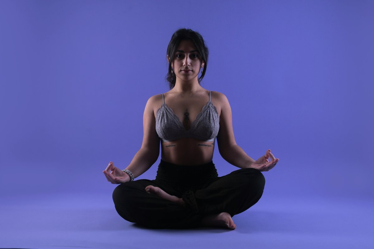 Woman practicing yoga and breathing exercises on a mat indoors, focused and calm