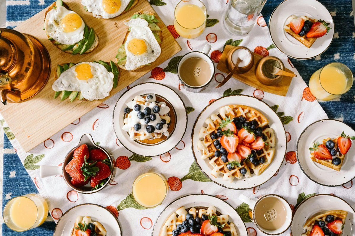 Healthy breakfast spread with waffles, eggs, fruit and morning beverages