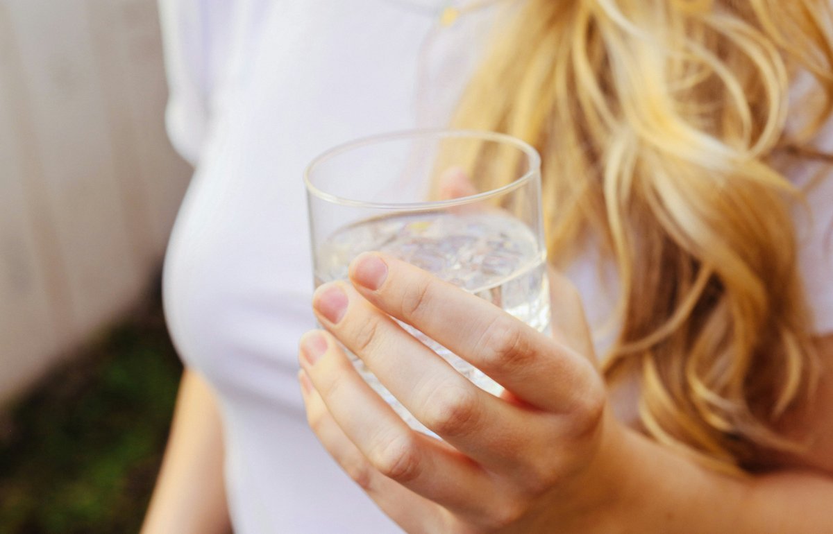 Woman holding a glass of water for morning hydration