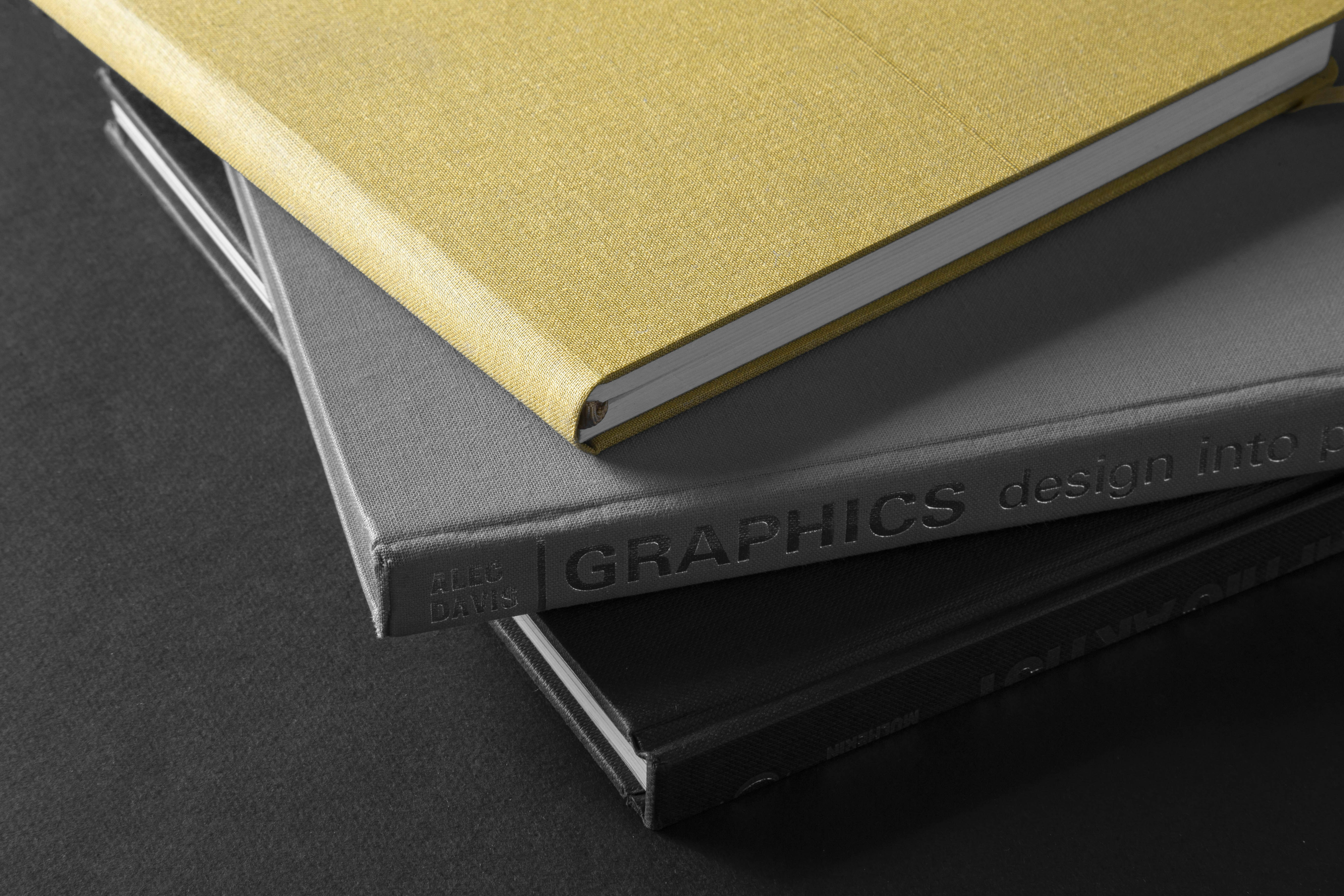 A collection of custom coil notebooks showing different cover finishes like foil stamping and embossing