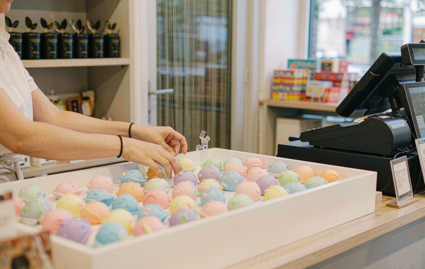 An open counter display of colourful squishy toys beside a store till