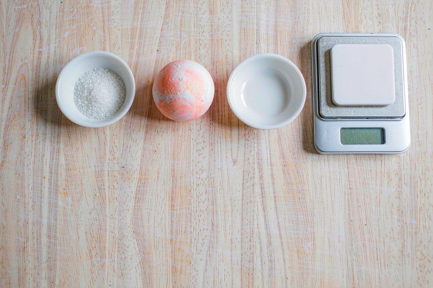 A soft-fill squishy ball beside bowls of filling and a scale on a factory bench
