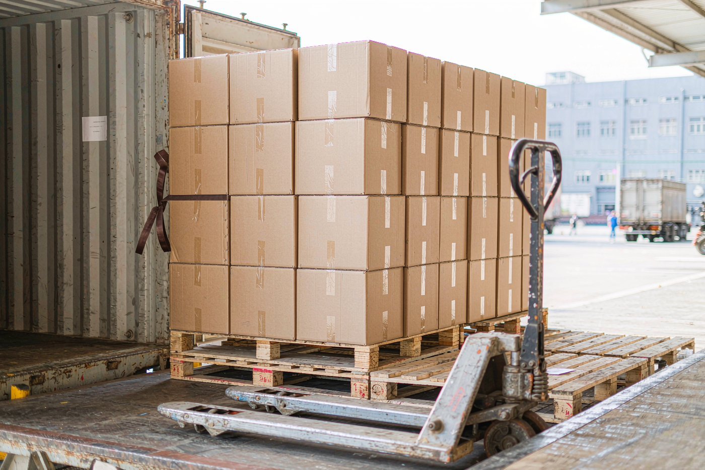 Cartons of goods on pallets at a container loading bay