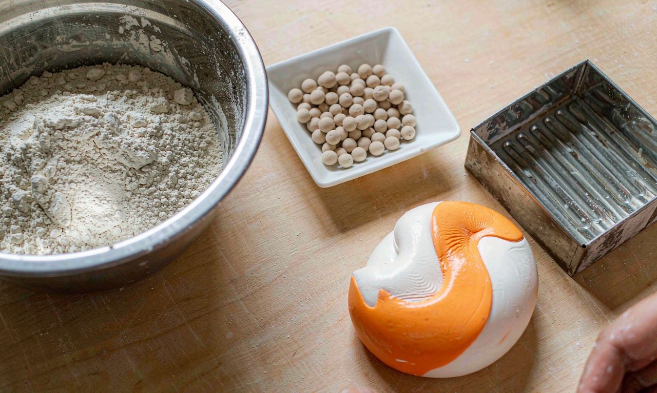 Filling materials, pellets, mould and finished squishy on a workshop bench