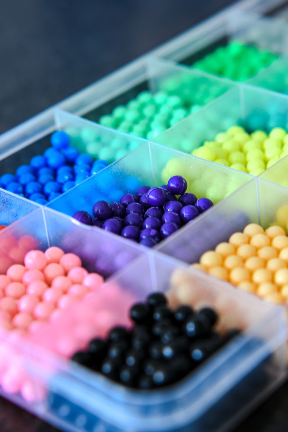 Colorful gel beads sorted in a compartmentalized plastic box