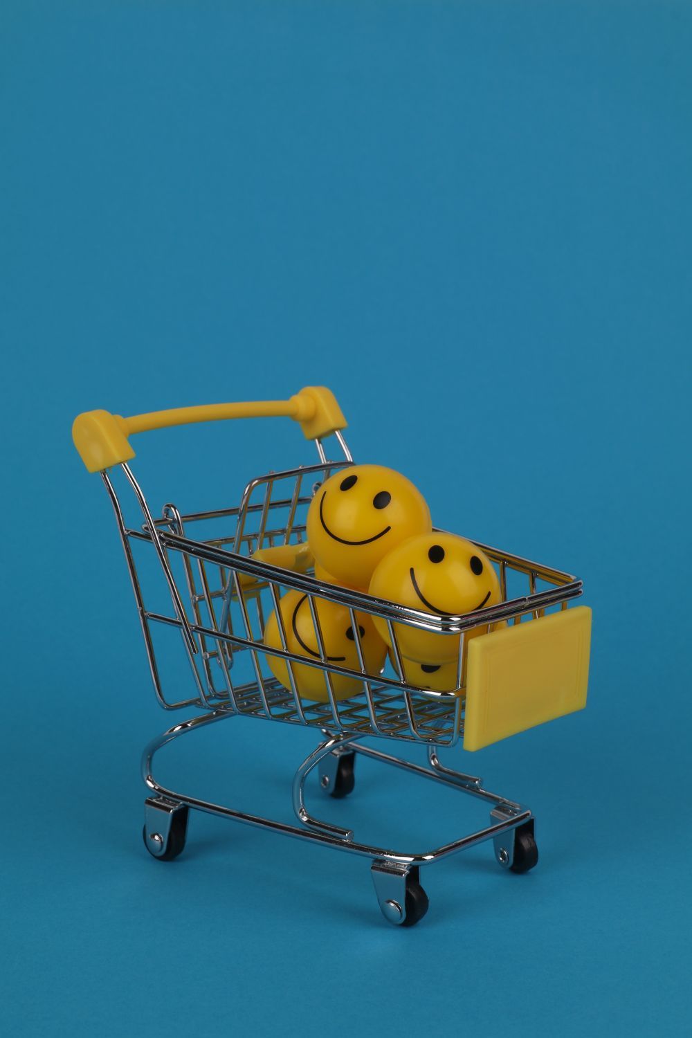 A miniature shopping cart filled with smiley-face stress balls