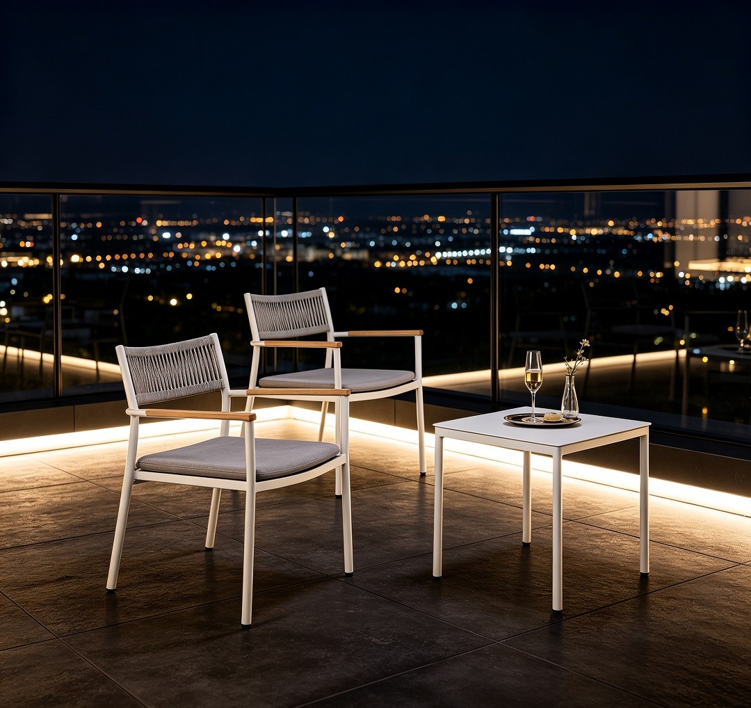 Hotel balcony furniture set on rooftop terrace at night with LED strip lighting and city skyline, two chairs with champagne