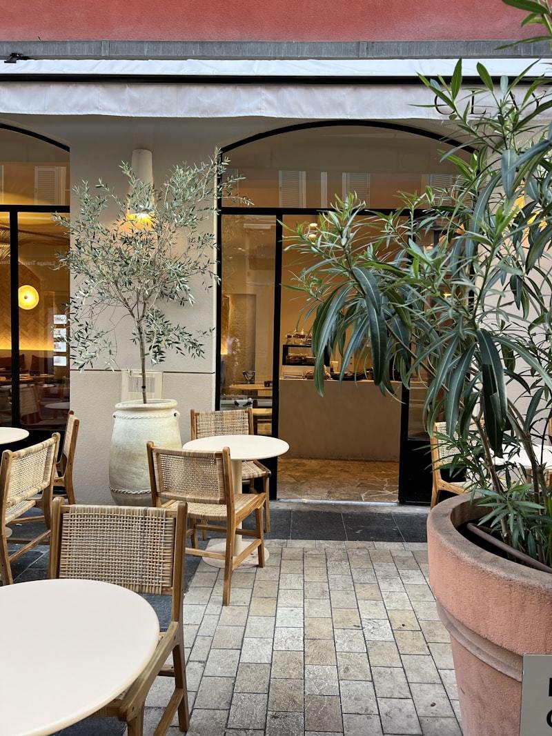 Restaurant patio with tables chairs and potted plants outdoor dining
