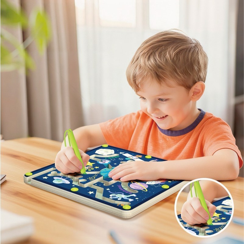 Toddler playing with space magnetic pen maze board on wooden table