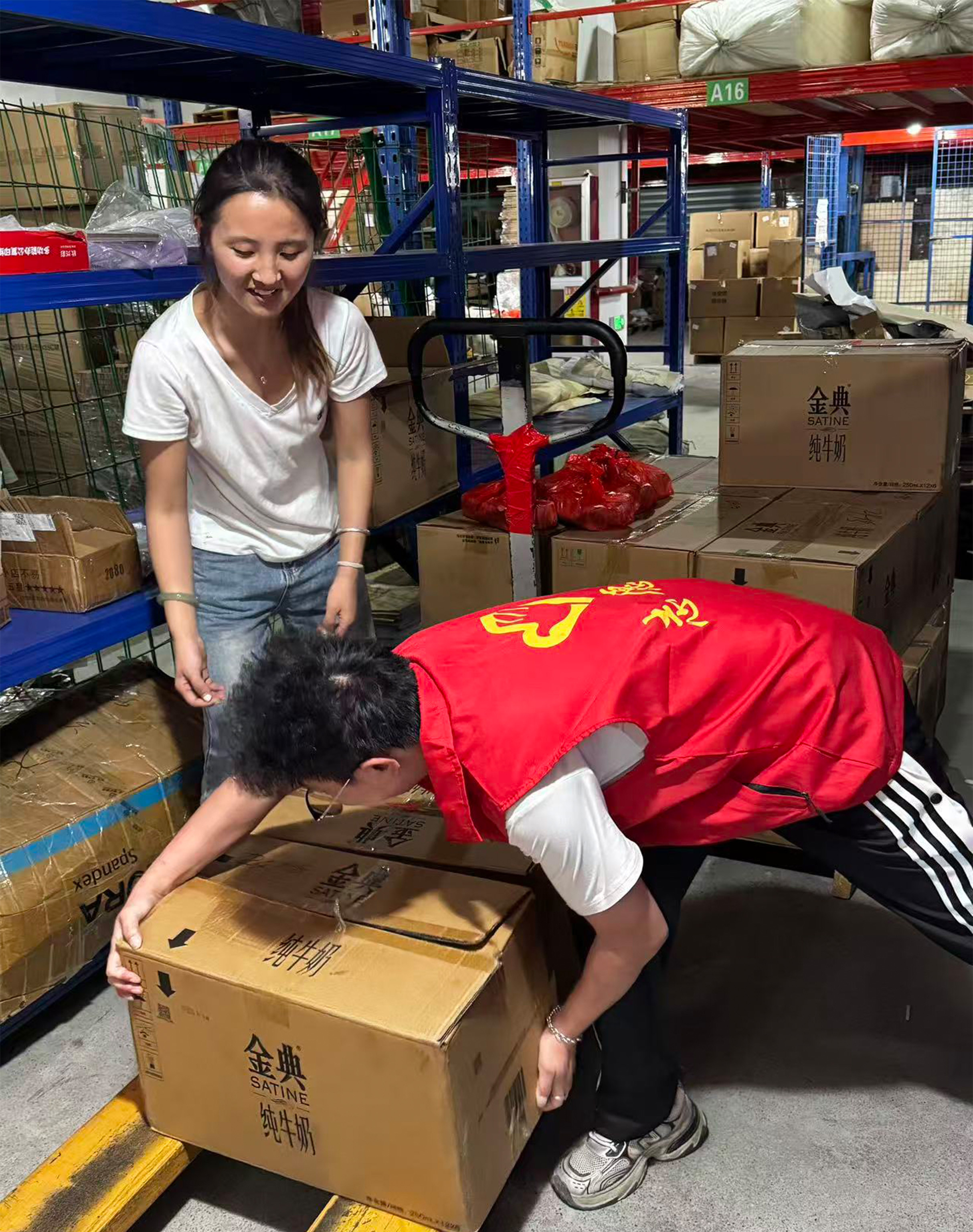 Cartons of milk and red Mid-Autumn gift bags staged in rows in the KIDMERRY warehouse