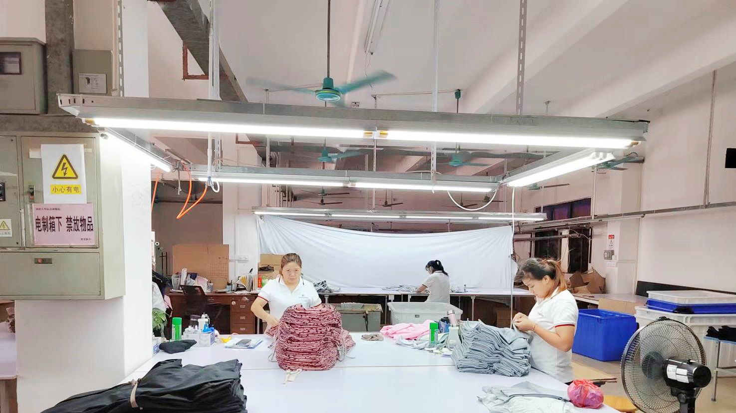 A quality control inspector examining a sports bra on a production line.
