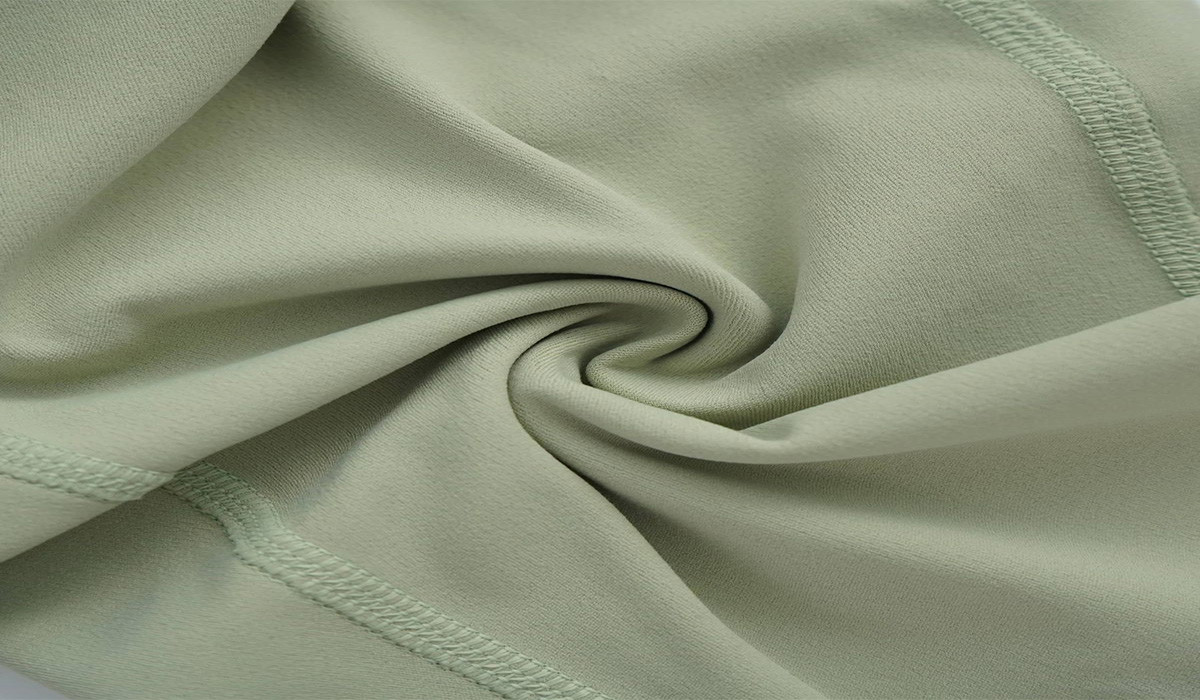 A person inspecting the fabric of a sustainable yoga top.