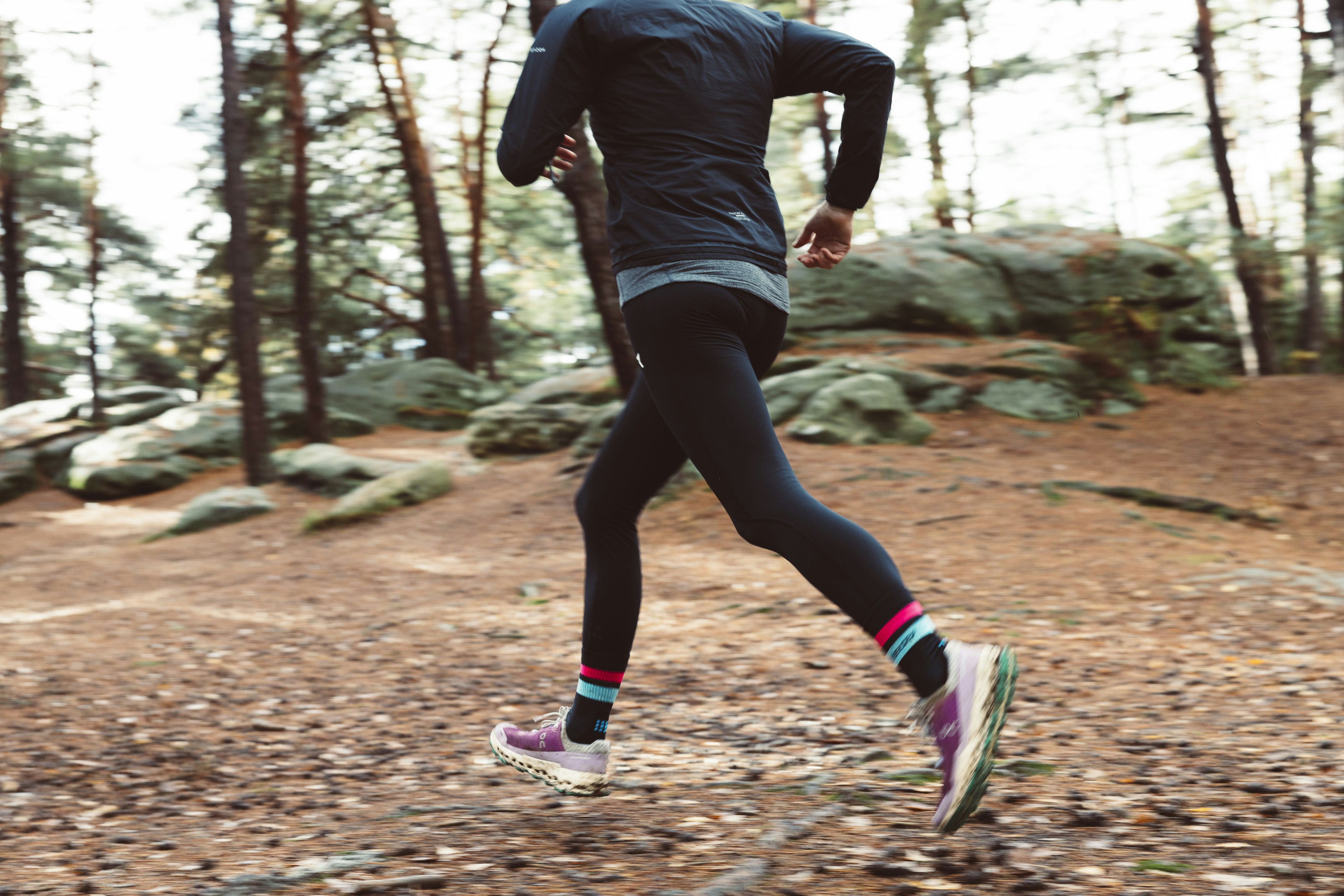 A person running outdoors in polyester spandex leggings, showcasing the fabric's suitability for high-performance activities.