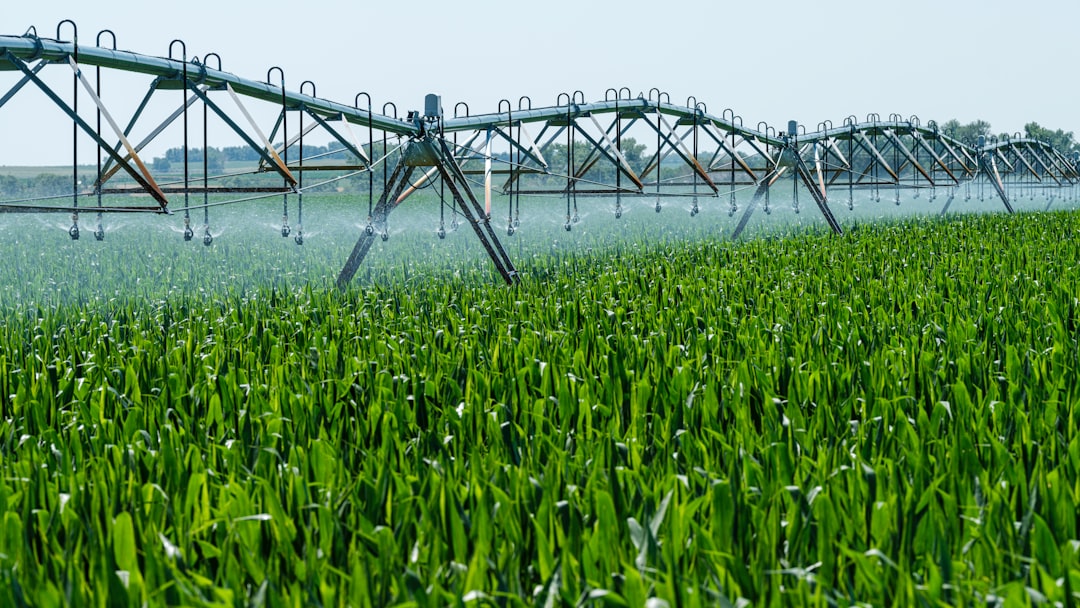 A large center-pivot irrigation system in a field, powered by a generator