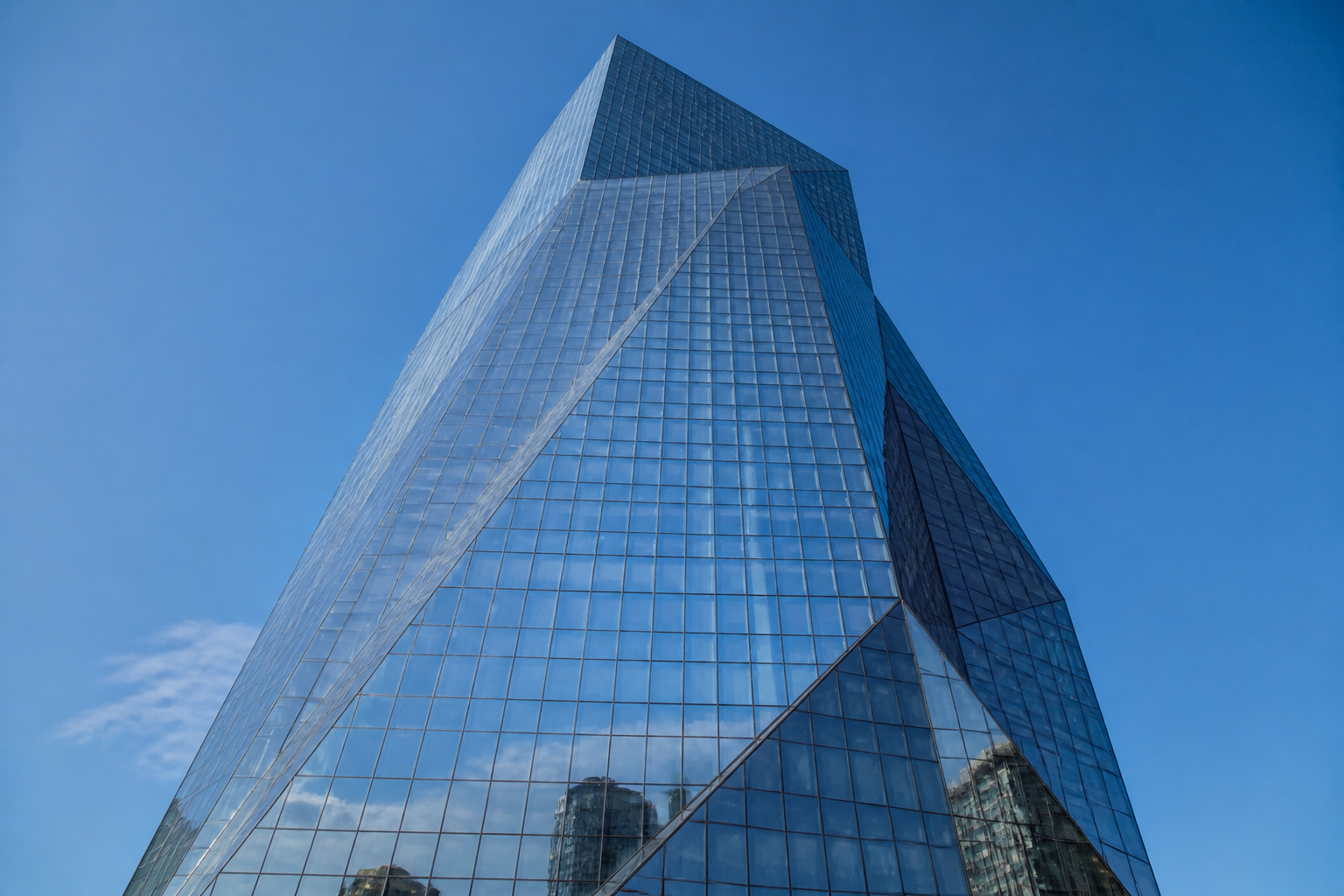 Iconic landmark skyscraper with geometric crystalline curtain wall facade