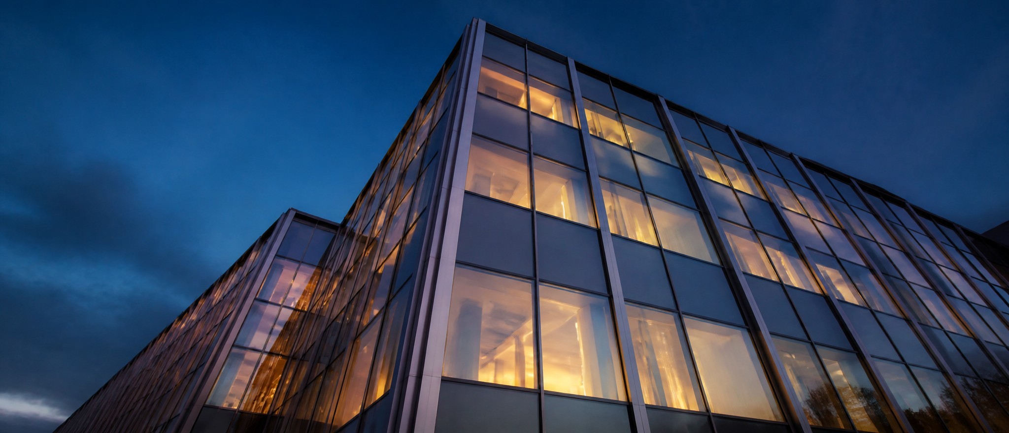 Glass curtain wall skyscraper facade at twilight