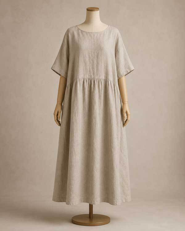 A KOSSR linen dress on a dress form showing relaxed fit with visible ease at waist, neutral studio background, clean ecommerce photography style with soft shadows