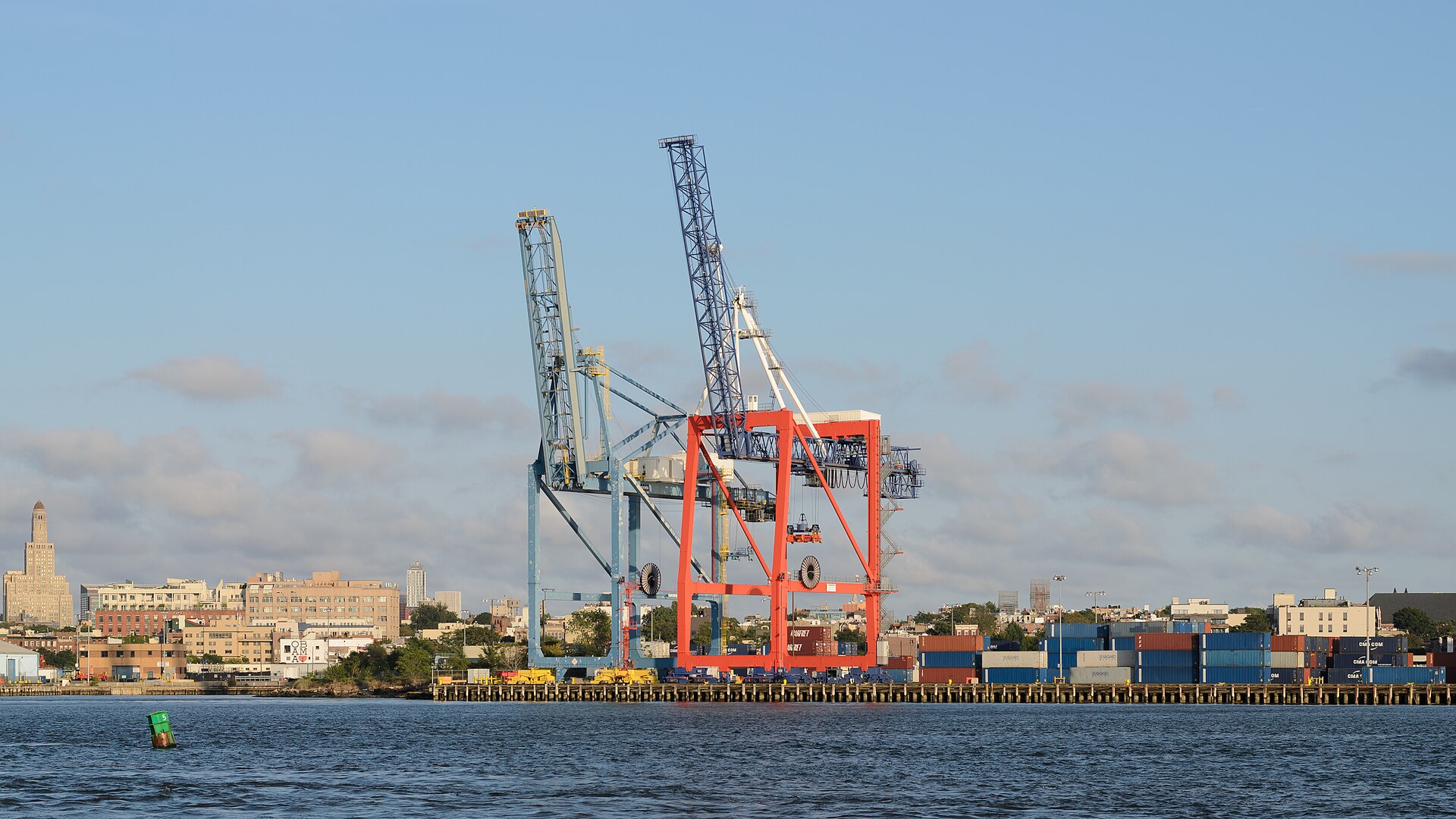 Container terminal with ship-to-shore cranes and stacked containers at a port of entry