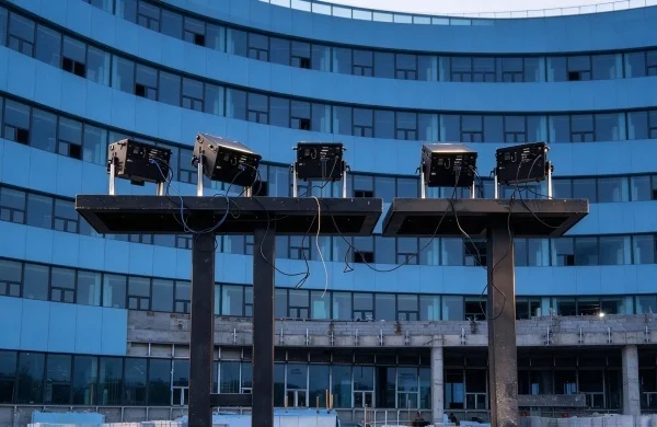 building facade lit in blue laser light during commissioning