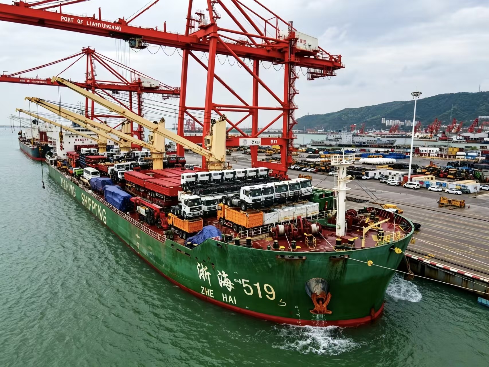 A break‑bulk vessel loads large quantities of construction vehicles at the terminal.