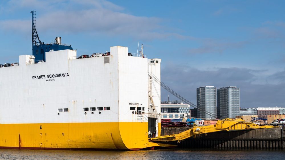 Con-ro vessel alongside a terminal, loading vehicles over its stern ramp