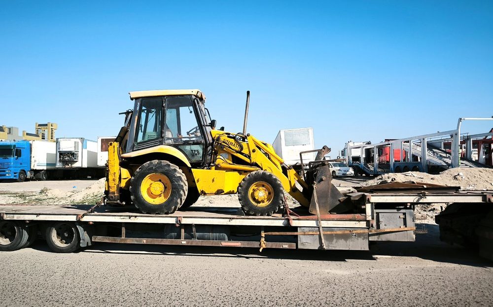 Over-dimensional machinery secured on an open flat platform trailer at a terminal
