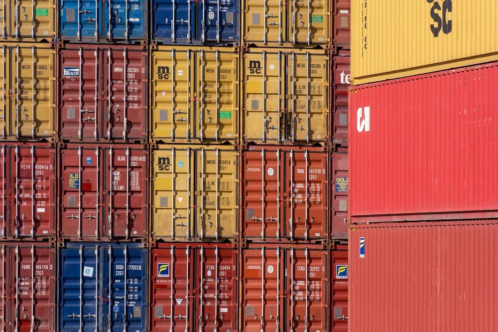 Stacked standard shipping containers in a port container yard