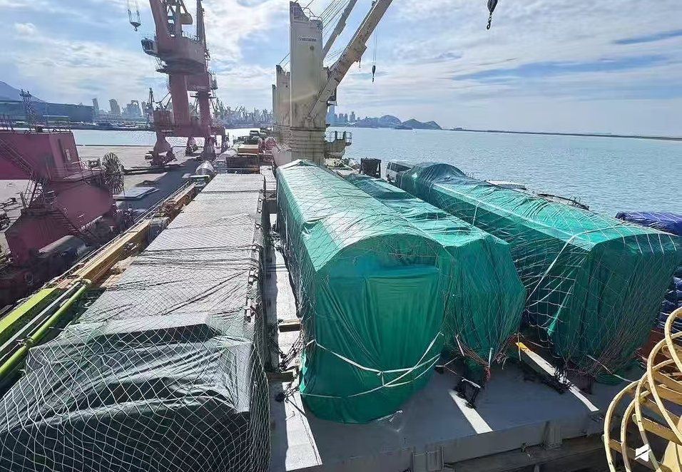 Cargo covered with tarpaulins and lashed on the deck of a vessel at the quay