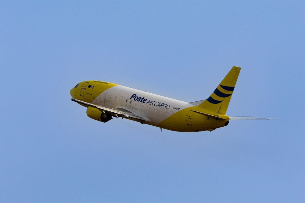 A freighter aircraft climbing after take-off against a clear sky