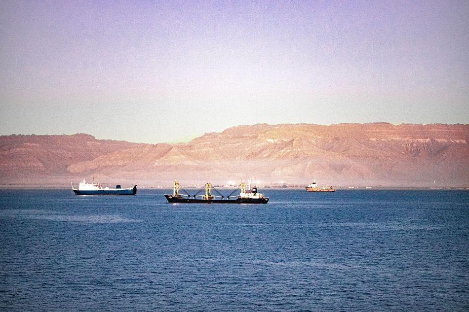 Cargo ships transiting the Suez Canal between desert banks