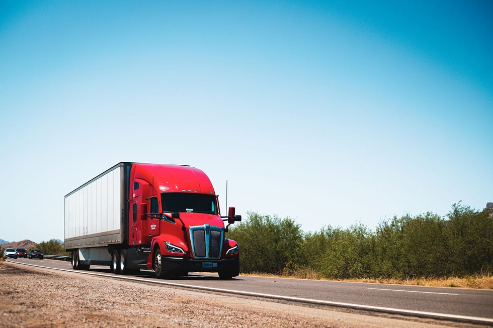 Tractor-trailer with a sealed box trailer driving on an intercity highway