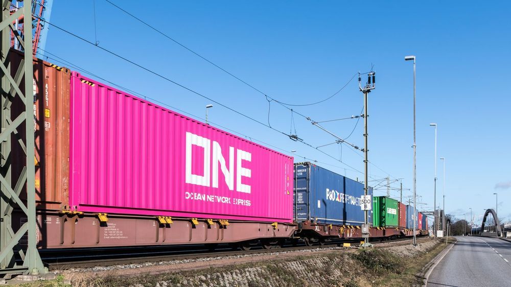 Block train carrying colourful shipping containers on the main line