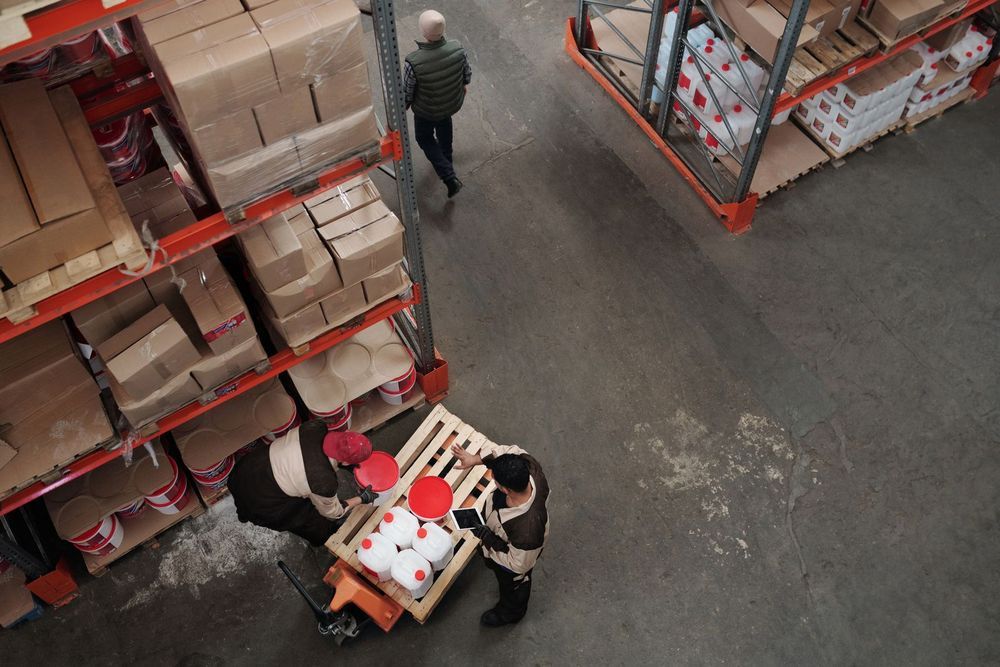 Warehouse team consolidating palletised cargo for a rail freight shipment