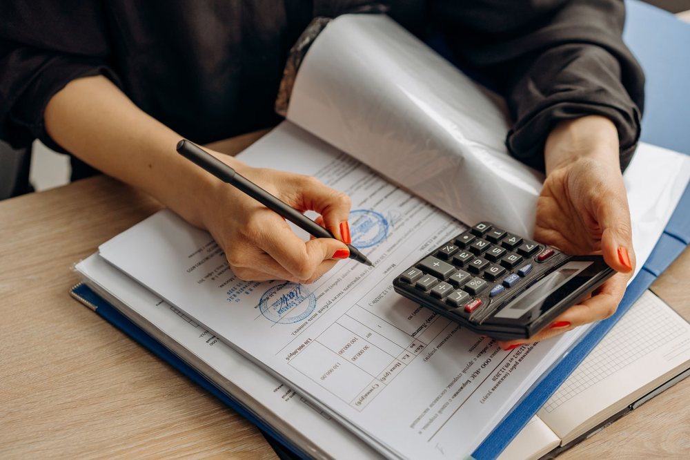 Forwarder reviewing shipping documents and insurance paperwork at a desk