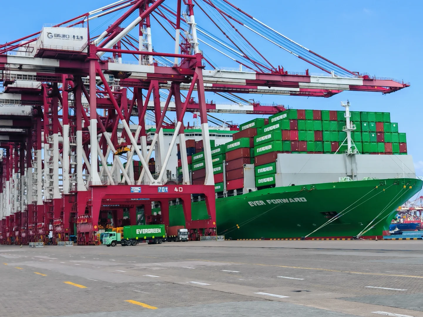 Stacked shipping containers at a busy commercial port